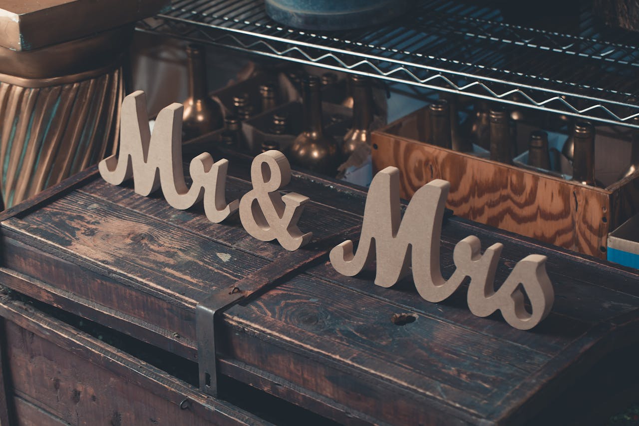 Close-up of rustic Mr & Mrs wooden decor on an antique chest in a cozy interior setting.